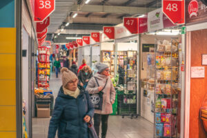 Kolorowe alejki handlowe w Hali Kupców Perła we Wrocławiu z dekoracjami i szerokim wyborem stoisk lokalnych dostawców.